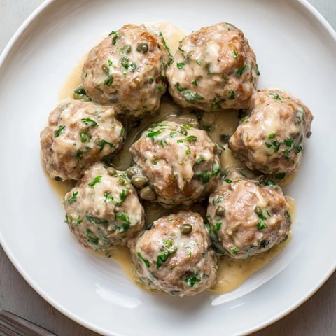 Zarte Königsberger Fleischbällchen in cremiger Kapernsoße, serviert mit Reis.